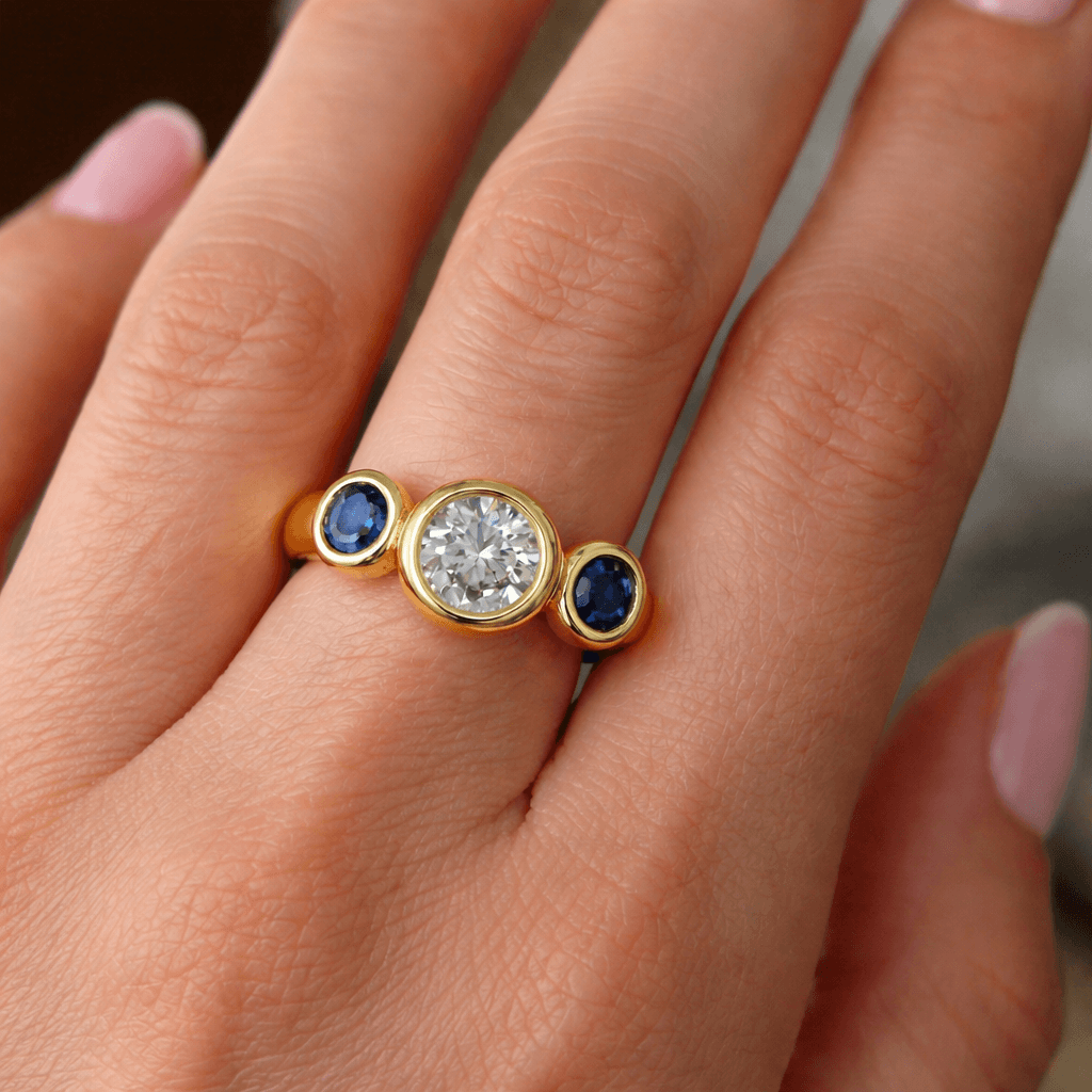 Bezel Set Three-Stone Round & Oval Cut White & Blue Sapphire Engagement Ring
