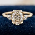 Classic Three Stone Oval Cut White Sapphire Engagement Ring In Yellow Gold