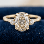 Classic Three Stone Oval Cut White Sapphire Engagement Ring In Yellow Gold