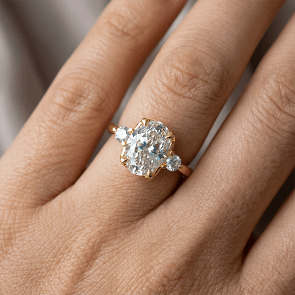 Classic Three Stone Oval Cut White Sapphire Engagement Ring In Yellow Gold